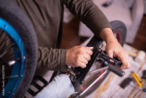 Man's hands tightening the pedals of a bicycle