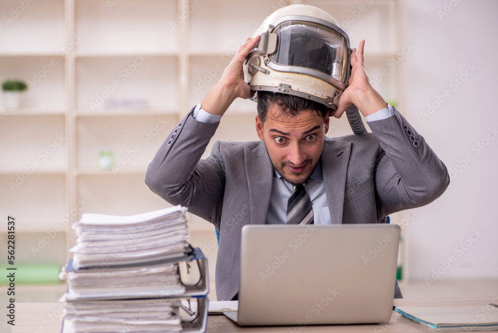 Young male employee wearing spacesuit in the office Young male employee wearing spacesuit in the office