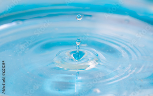light blue water drop splash on surface background.