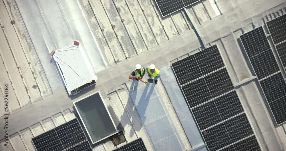 Solar energy, drone and construction workers on rooftop for engineering, architecture or grid. Aerial view, solar panels and industrial team working on project management, city logistics and building