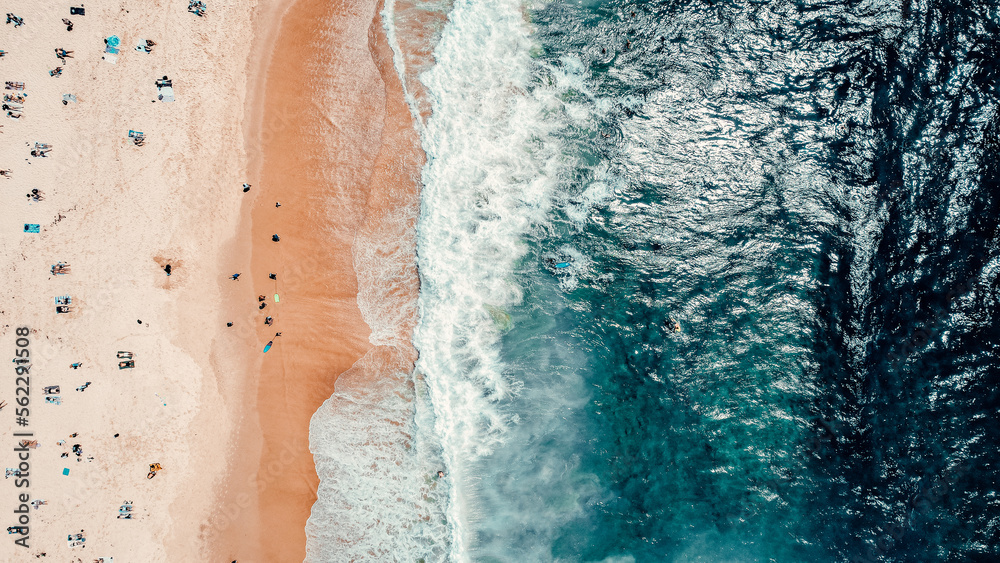 Aerial Drone Overhead Shot of Beach With People, Blue Water, Waves Crashing Onto Beach, Sunny