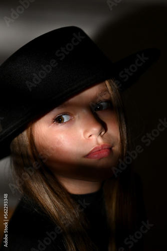 Girl in a black hat, portrait of a beautiful young woman in retro style in an elegant black hat. A romantic image.