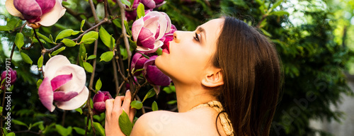 Beautiful woman face, spring banner for website header. Beauty spring girl with magnolia Flovers. Tenderness sensual woman. Passion and sensual touch.