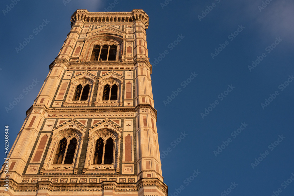 Low angle view of the Duomo tower against blue clear sky. Sunset.