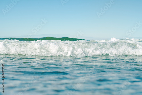 Close-up of the sea surface in soft focus. Warm waves of the ocean. Background on the theme of a pleasant romantic holiday. Beach vacation from work.