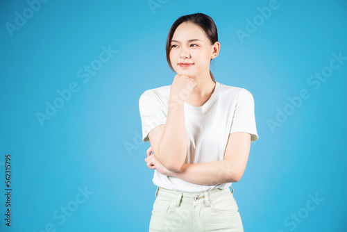 Portrait of young Asian woman standing on blue background