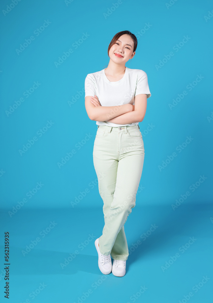 Full length photo of young Asian woman standing on blue backround Full length photo of young Asian woman standing on blue backround