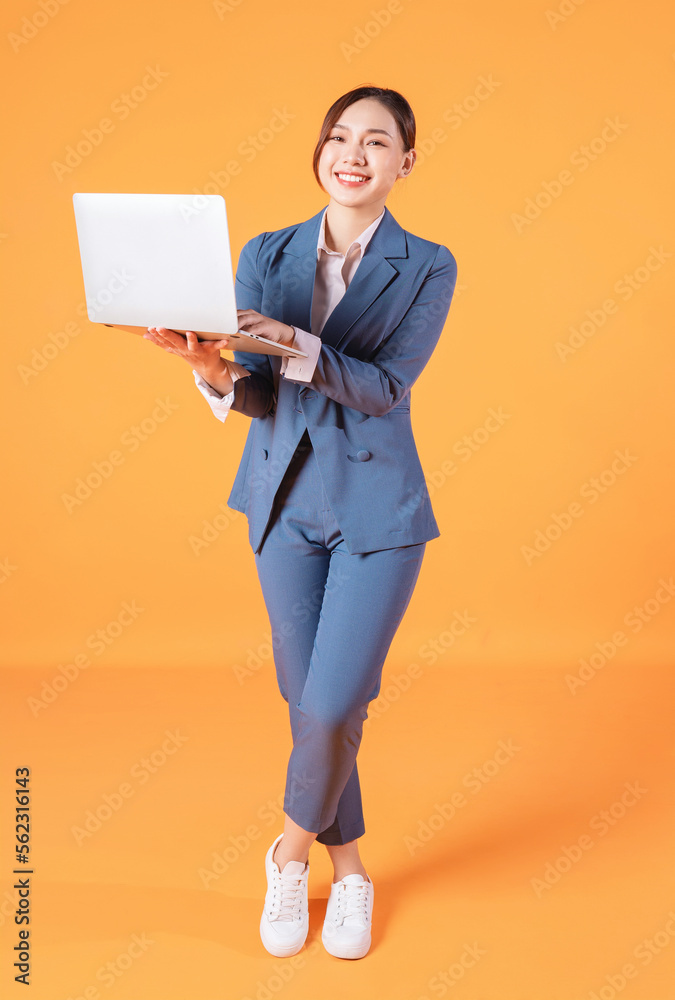 Full length image of young Asian business woman on background Full length image of young Asian business woman on background