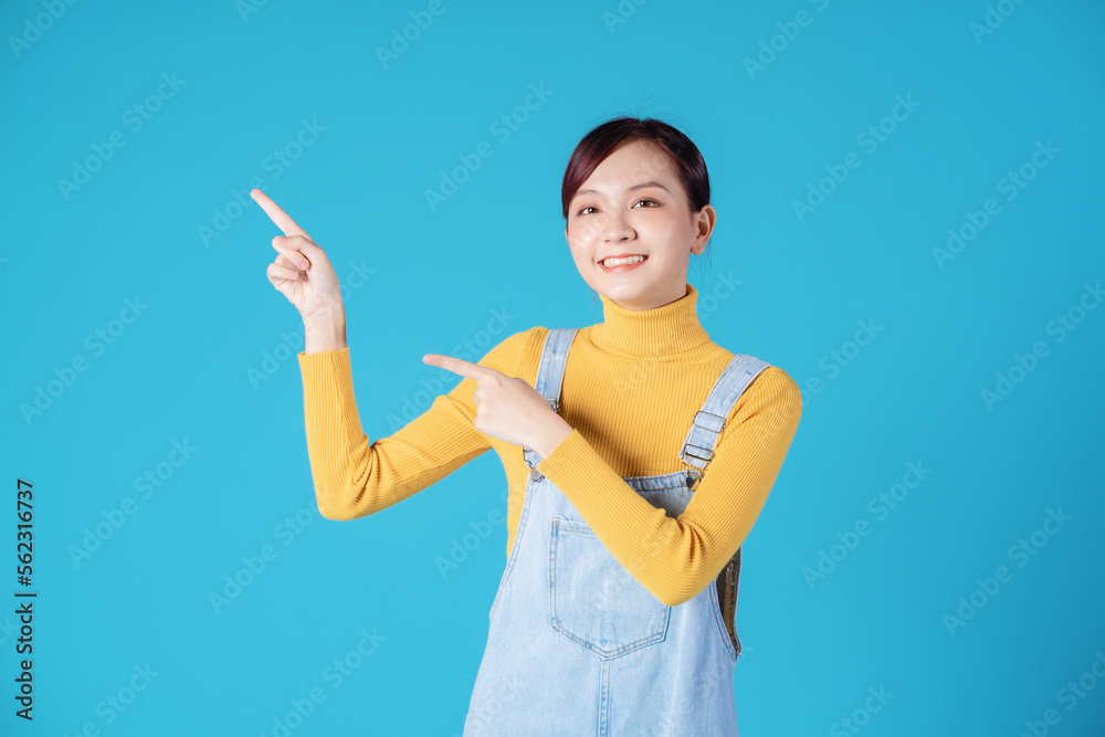 Young Asian girl posing on blue background Young Asian girl posing on blue background