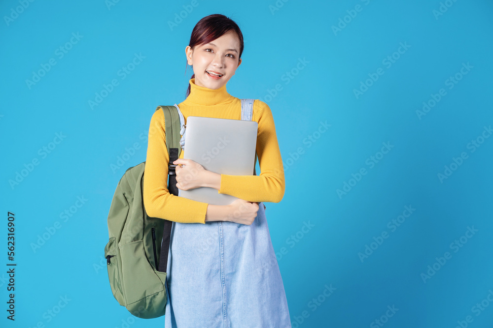 Obraz premium Young Asian student posing on blue background
