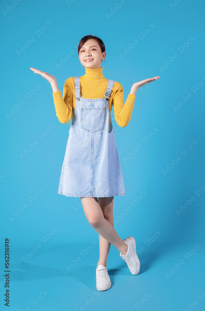Full length photo of young Asian girl standing on blue background Stock ...