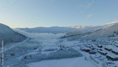 Cold Myrkdalen valley during early morning sunrise with frosty haze in background - Aerial besides road rv-13 looking in direction of Voss and Vinje Norway with Vossestrand hotel to the right photo