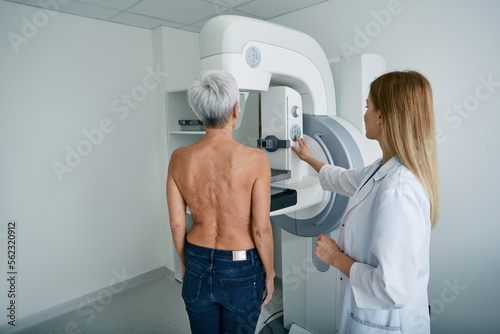 Mammography test. X-ray breast examination of mature female patient with radiology technician in mammography radiology room at medical clinic photo