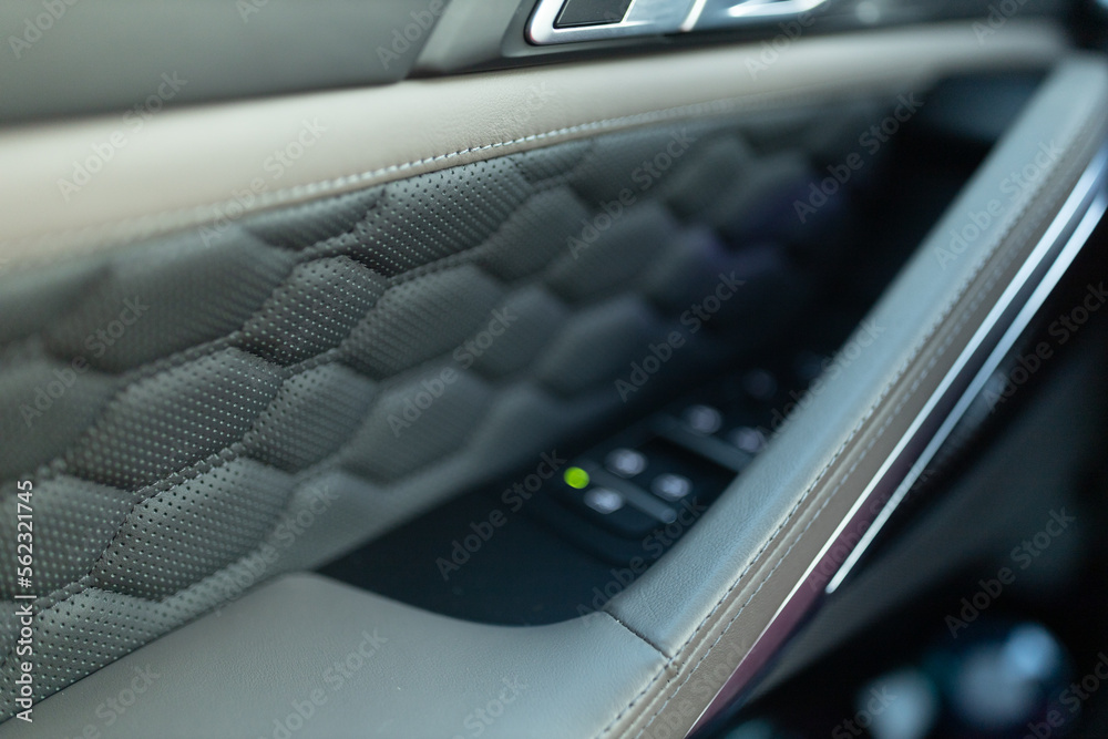 Leather panel with honeycomb line at the door. Modern SUV interior close up and selective focus 