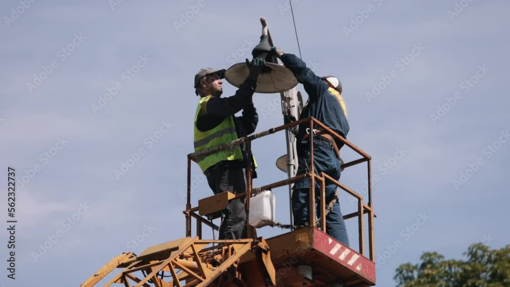 during installation, worker repair, metal pole. Worker is fixing street