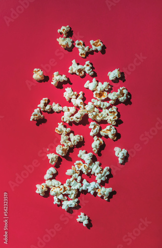 Scattered salty popcorn on viva magenta color background, top view © 5ph