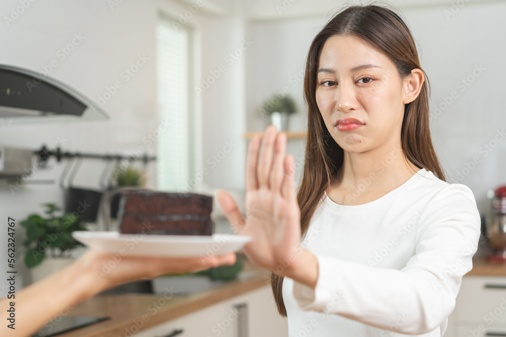 Diet, Dieting asian young woman, girl hand deny, rejecting to eat chocolate cake or sweet taste, fighting to keep it from getting fat when people giving to me. Health care, nutrition of weight loss. Diet, Dieting asian young woman, girl hand deny, rejecting to eat chocolate cake or sweet taste, fighting to keep it from getting fat when people giving to me. Health care, nutrition of weight loss.