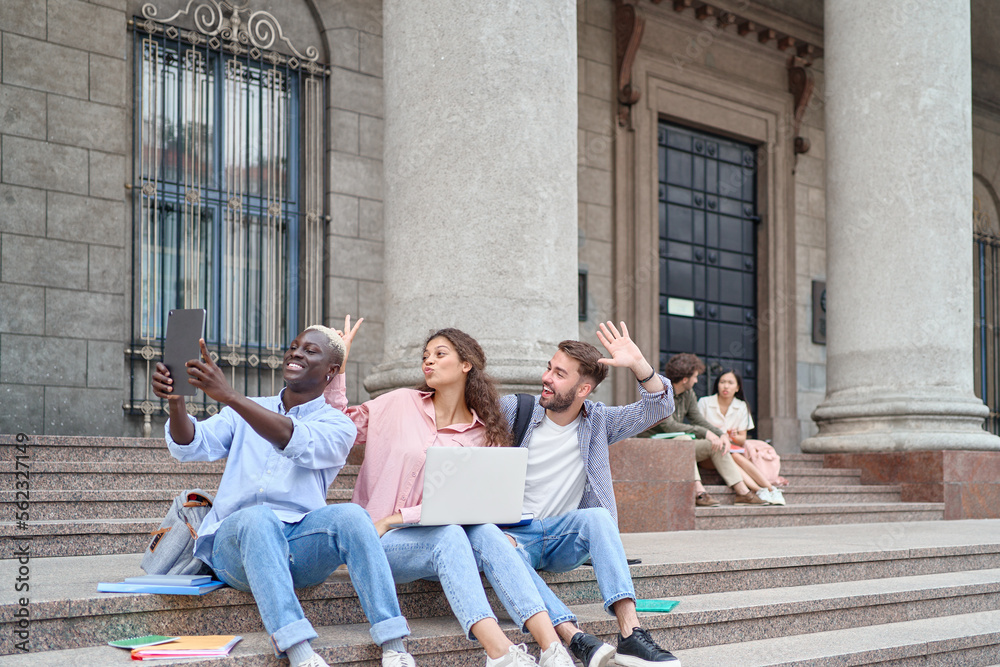Fototapeta premium students with a laptop and a digital tablet sitting on the steps.