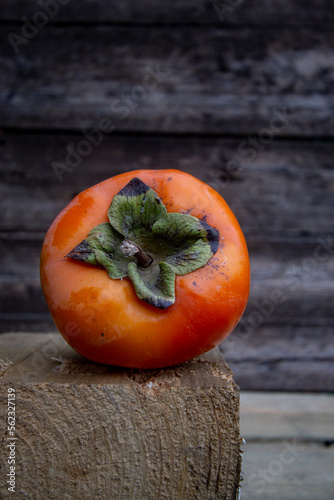 big ripe orange persimmon on wooden background