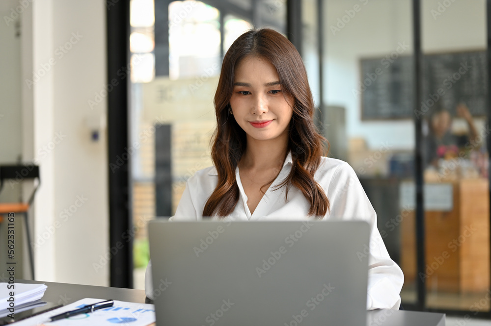 Beautiful Asian businesswoman or female secretary is working in her office, using laptop computer. Beautiful Asian businesswoman or female secretary is working in her office, using laptop computer.