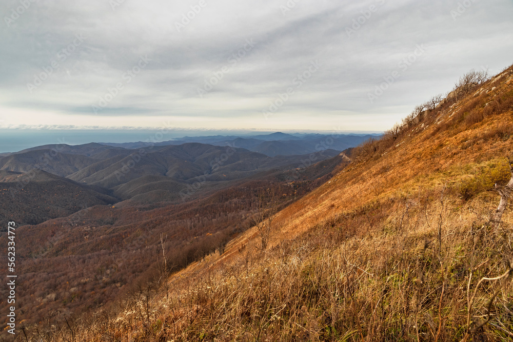 View from a height of 1000 m to the peaks of the Caucasus. Stunning view from the rocky peak of Mount Peus on a sunny day. Picturesque view of the mountain peaks of the Caucasus on a sunny day. View from a height of 1000 m to the peaks of the Caucasus. Stunning view from the rocky peak of Mount Peus on a sunny day. Picturesque view of the mountain peaks of the Caucasus on a sunny day.