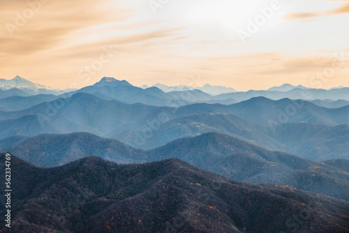 View from a height of 1000 m. Stunning view of the ridge of mountain peaks from a height. Mountain peaks of the Caucasus on a sunny day. A magnificent mountain range with high peaks.