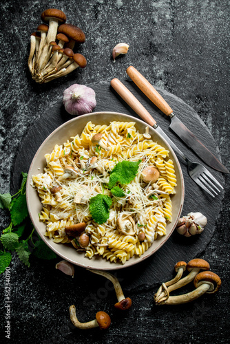 Fusilli pasta in a bowl of mushrooms and garlic. © Artem Shadrin