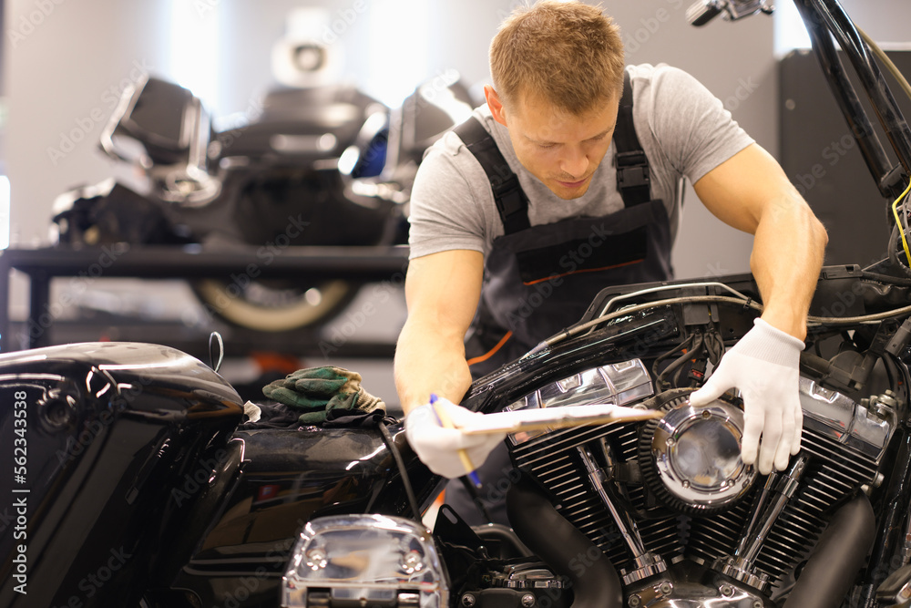 Master diagnoses and repairs motorcycle in workshop Master diagnoses and repairs motorcycle in workshop