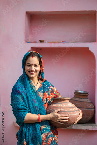 Indian rural woman carrying water pot photo