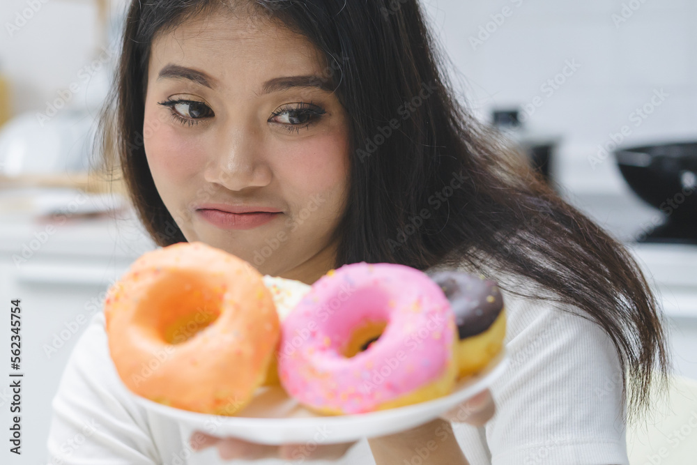 Avoid sweat for good shape. woman looking at sweet donut. Avoid sweat for good shape. woman looking at sweet donut.