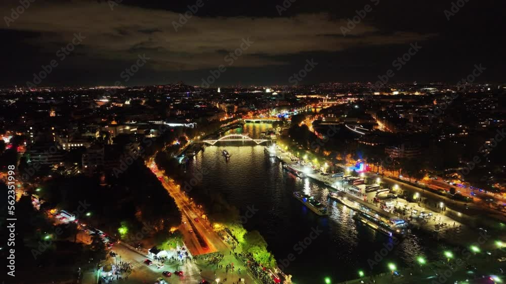 Just stunning aerial of the river running through the city of Paris in France during night with the city lights lighting up the sky clouds Just stunning aerial of the river running through the city of Paris in France during night with the city lights lighting up the sky clouds