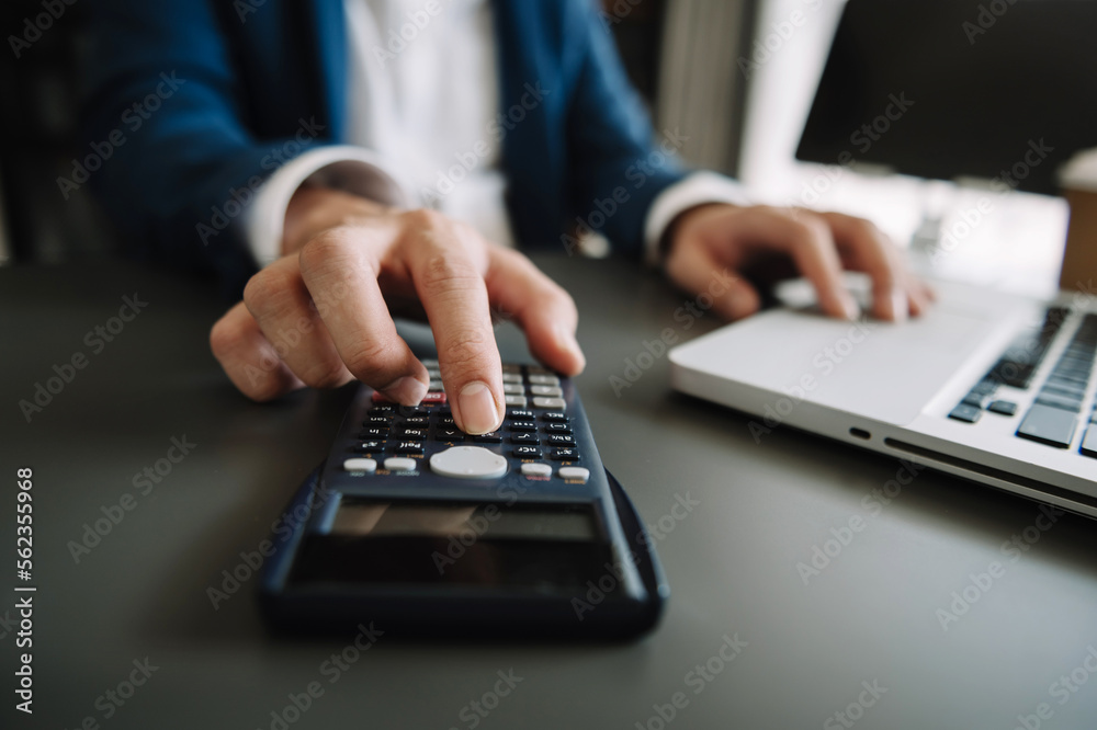Women counting coins on calculator taking from the piggy bank. hand holding pen working on calculator to calculate on desk about cost at home office... Women counting coins on calculator taking from the piggy bank. hand holding pen working on calculator to calculate on desk about cost at home office...