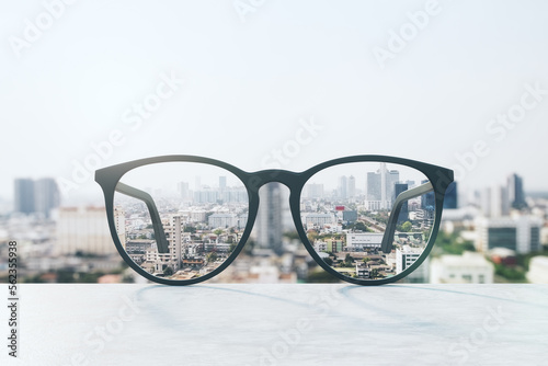 Look through glasses at blurred city with mock up place on sky texture. Vision and perspective concept. 3D Rendering.