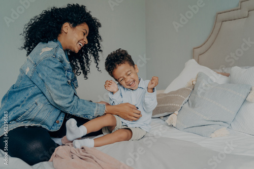 African american woman having fun with little adorable son at home