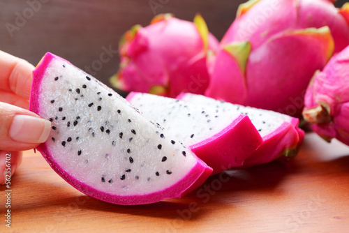 Woman's Hand Picking a Slice of Delectable Fresh Ripe Dragon Fruit