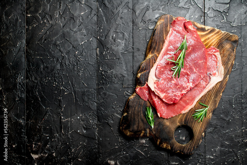 Raw beef steaks with fragrant rosemary.