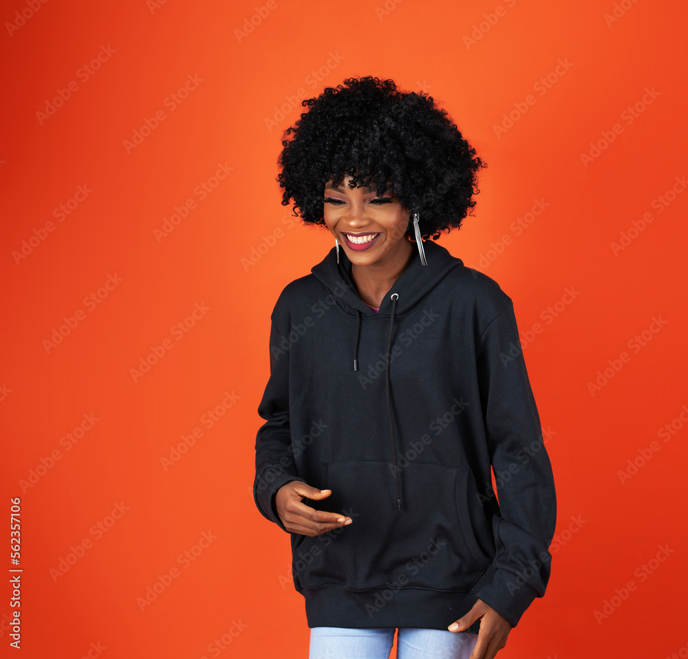 A lady on afro, wearing a black hoodie A lady on afro, wearing a black hoodie