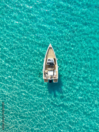aerial view of a boat anchored on a beach with turquoise waters. Concept of holidays, luxury a relax  © Enrique