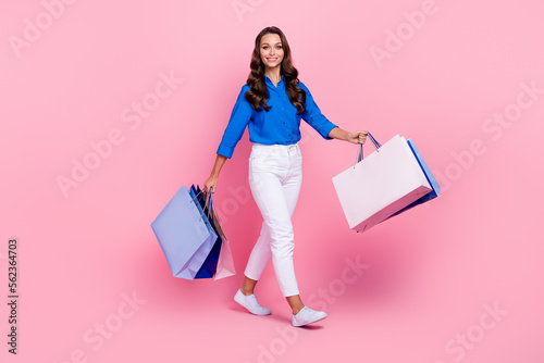 Full length size photo of optimistic business woman wear blue shirt hold packages black friday bershka collection isolated on pink color background photo