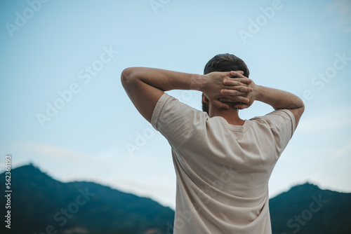 happy handsome man relax nature, young calm carefree man traveler with open raised hands enjoy mountain, one person feeling good, breath deep deeply fresh air. Freedom, travel, happiness concept