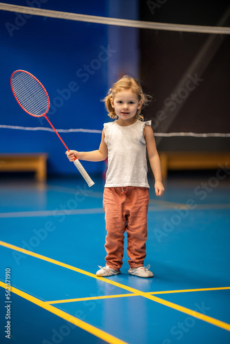 Little girl three years old playing badminton in sport wear on indoor court  © dtatiana
