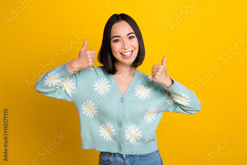 Photo of positive japanese girl wear daisy blue ornament pullover thumbs up recommend new shopping mall isolated on yellow color background
