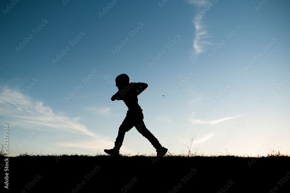 Silhouetted Boy Running on Hill in Waco Texas Silhouetted Boy Running on Hill in Waco Texas