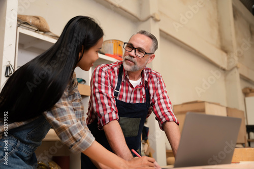 Fotografija Couple carpenter lovers using laptop to check model picture, requirement from customer before order material from supplier