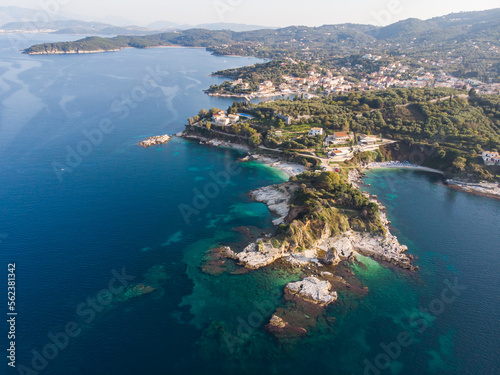 Aerial drone view of Kassiopi, village in northeast coast of Corfu island, Ionian Islands, Kerkyra, Greece in a summer sunny day, with marina, town, beach and castle