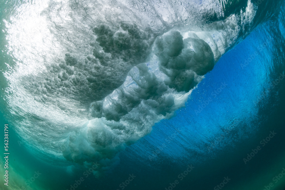 underwater scene of a huge crashing wave in the ocean