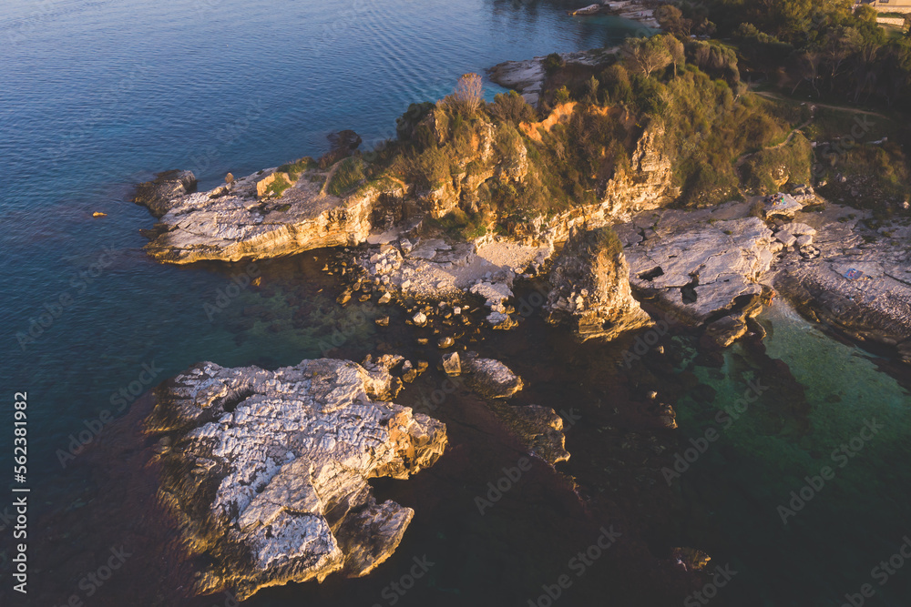 Aerial drone view of Kassiopi, village in northeast coast of Corfu island, Ionian Islands, Kerkyra, Greece in a summer sunny day, with marina, town, beach and castle Aerial drone view of Kassiopi, village in northeast coast of Corfu island, Ionian Islands, Kerkyra, Greece in a summer sunny day, with marina, town, beach and castle