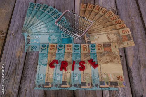 Banknotes of 50 and 100 reais on a wooden background, written 