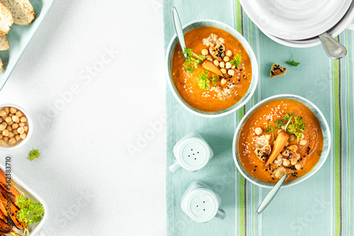 Vegetarian autumn pumpkin and carrot soup with cream, seeds and cilantro micro greens. Comfort food