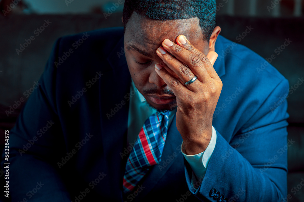 Black or African American business man sitting down looking anxious and depressed